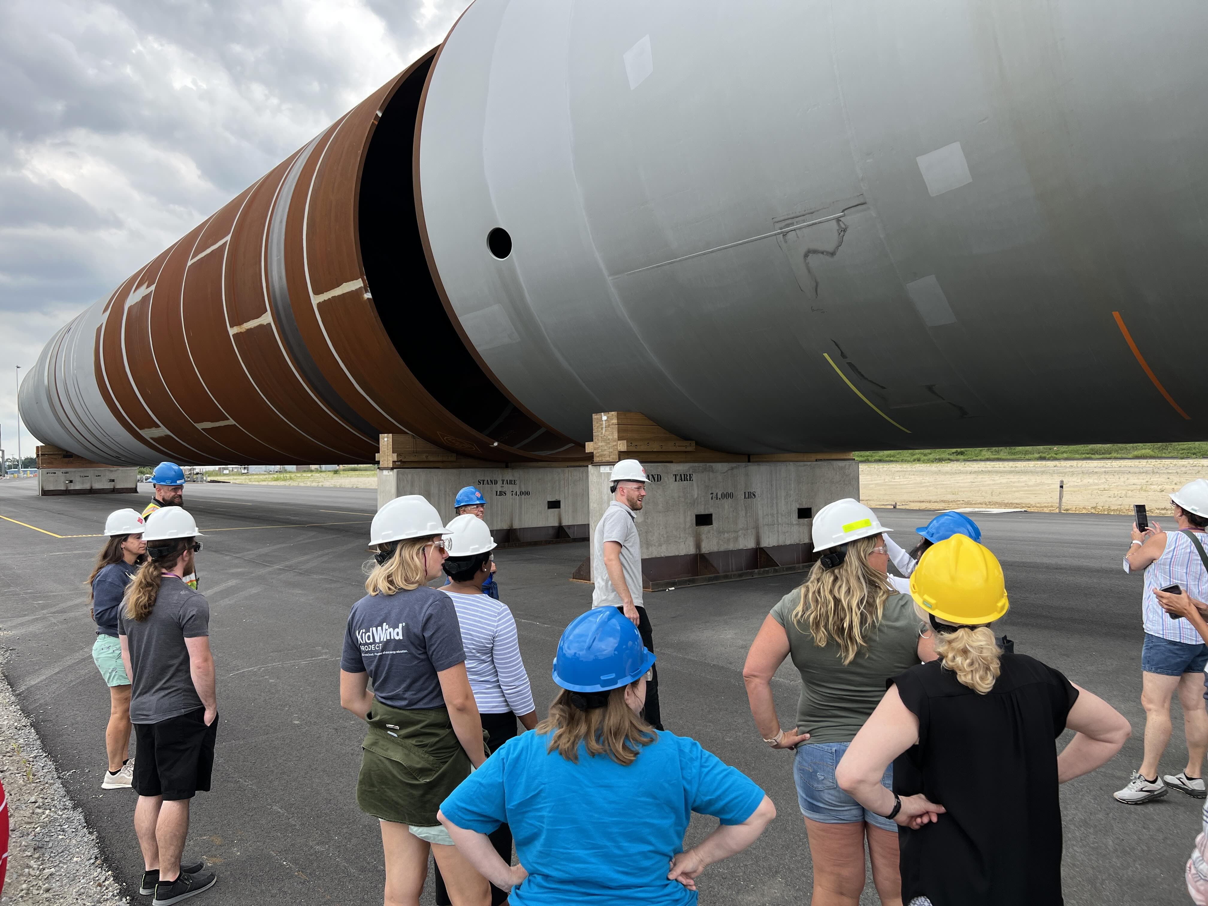 Students stand in front of monopile foundations for offshore wind turbinestour at REcharge Academy in Paulsboro, New Jersey,Students stand in front of monopile foundations for offshore wind turbinestour at REcharge Academy in Paulsboro, New Jersey